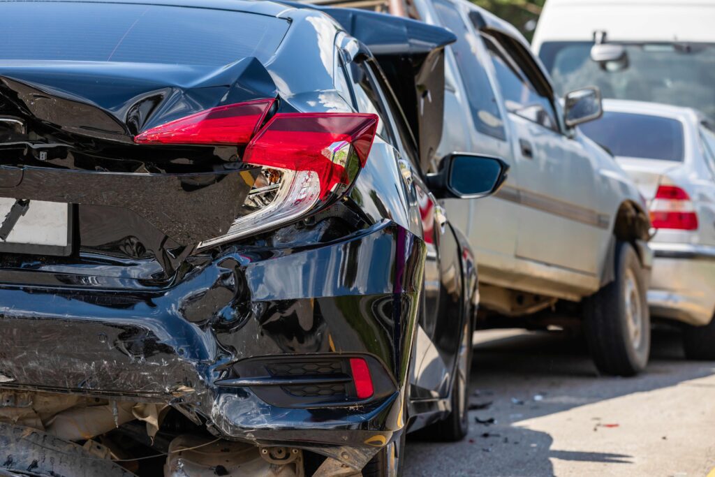 car accident involving the bumper of a black car and silver car