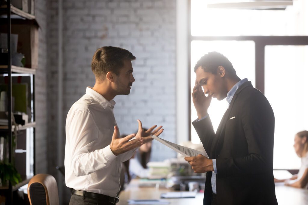 dispute between two men arguing in a brick room with conference table