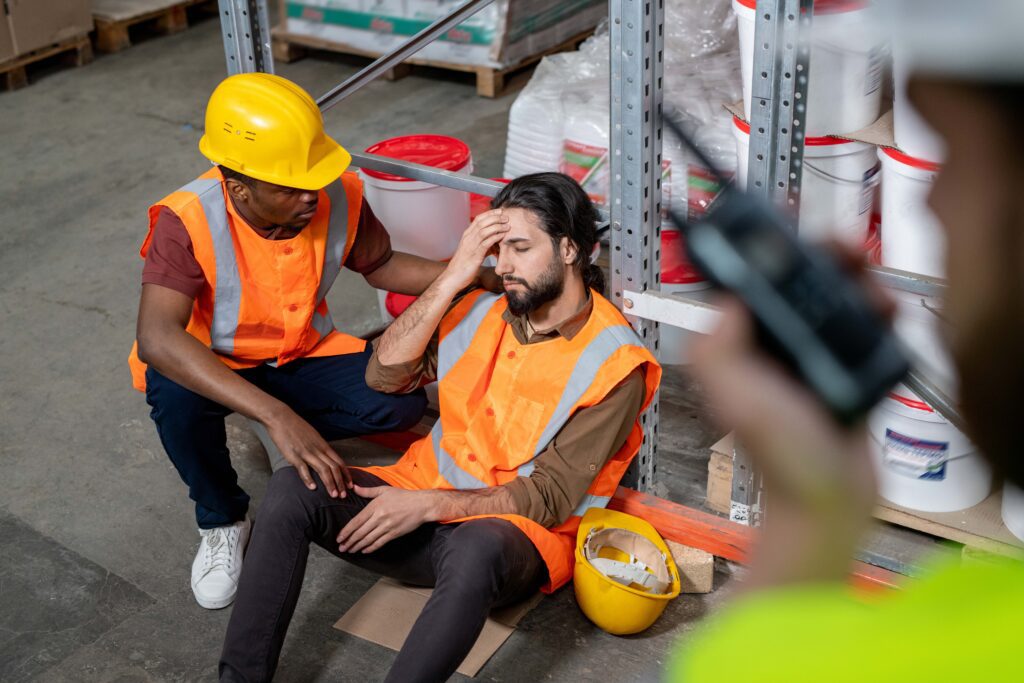 warehouse employee helping another employee feel better